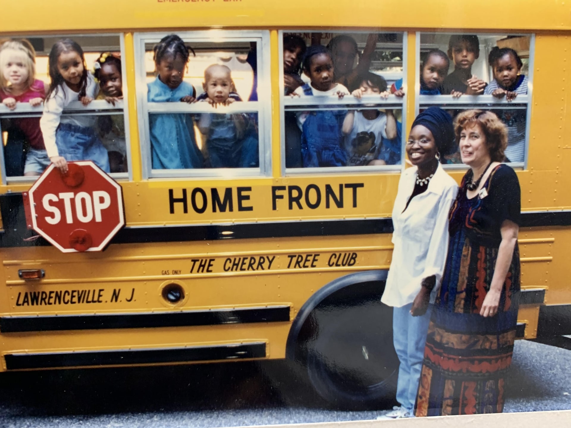 a group of people standing in front of a school bus